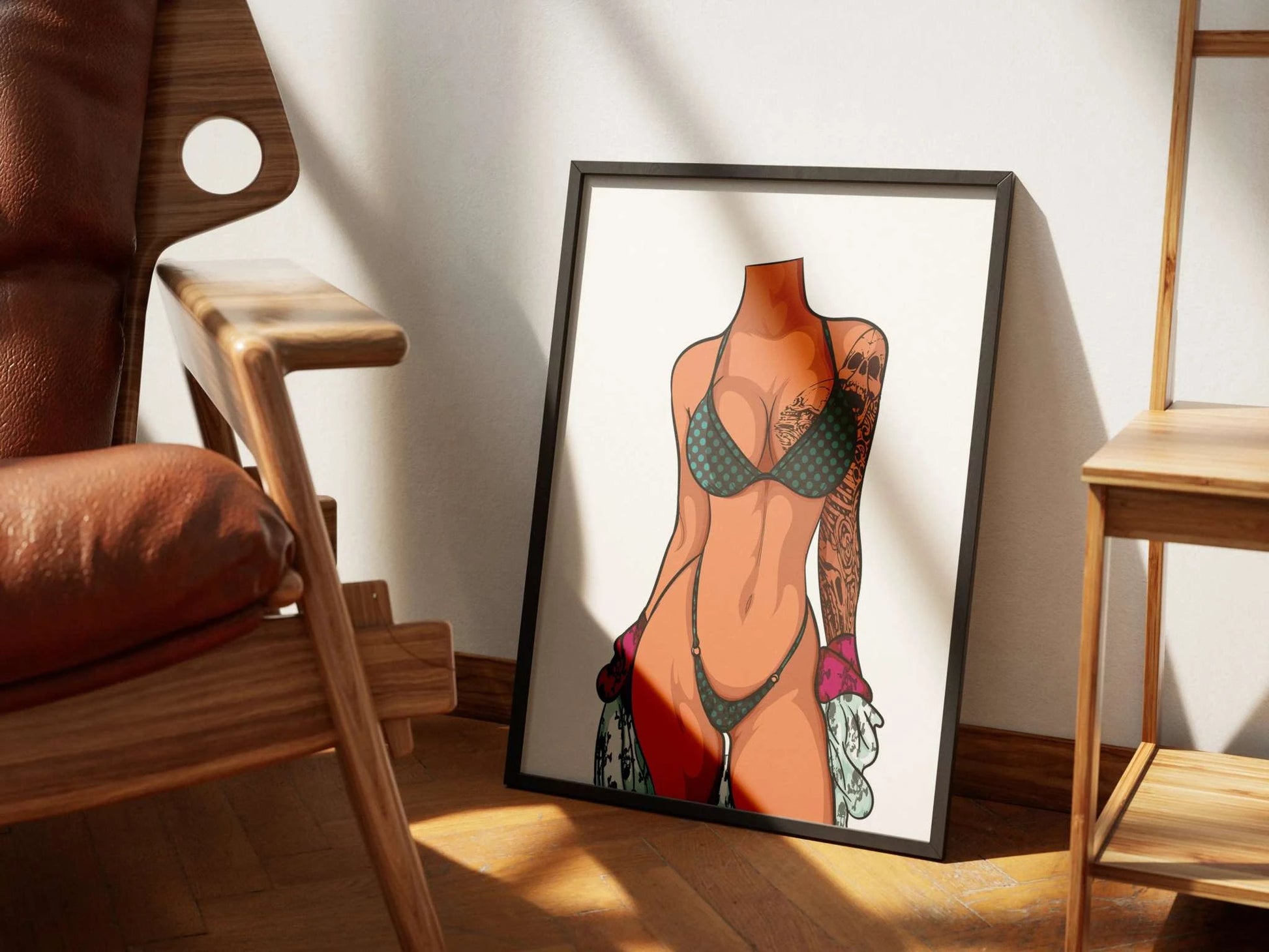 Minimalist digital bikini art framed and placed on the floor by a chair, featuring Model 1 - Baked Art.