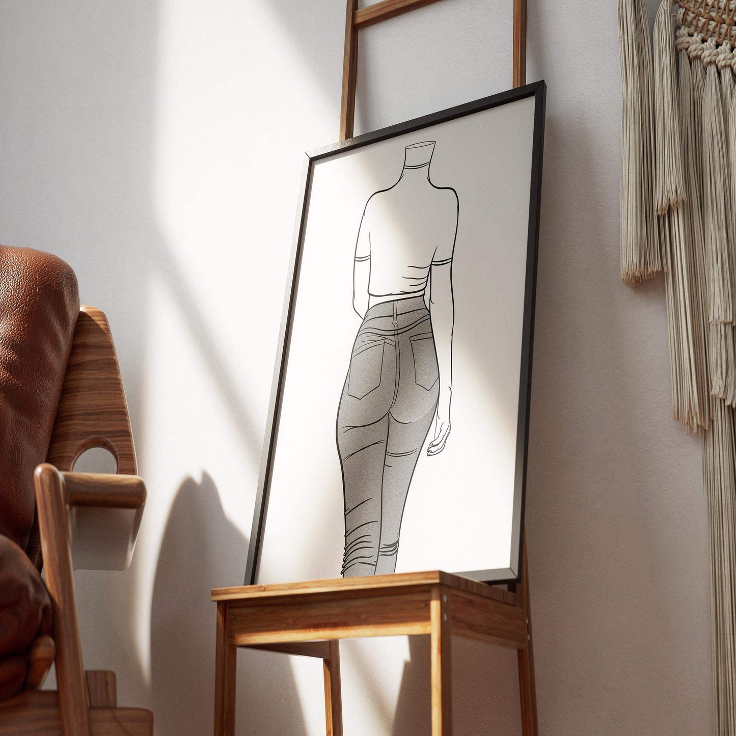 Digital line art of a figure wearing jeans denim, framed on a wooden stand in a stylish room setting.