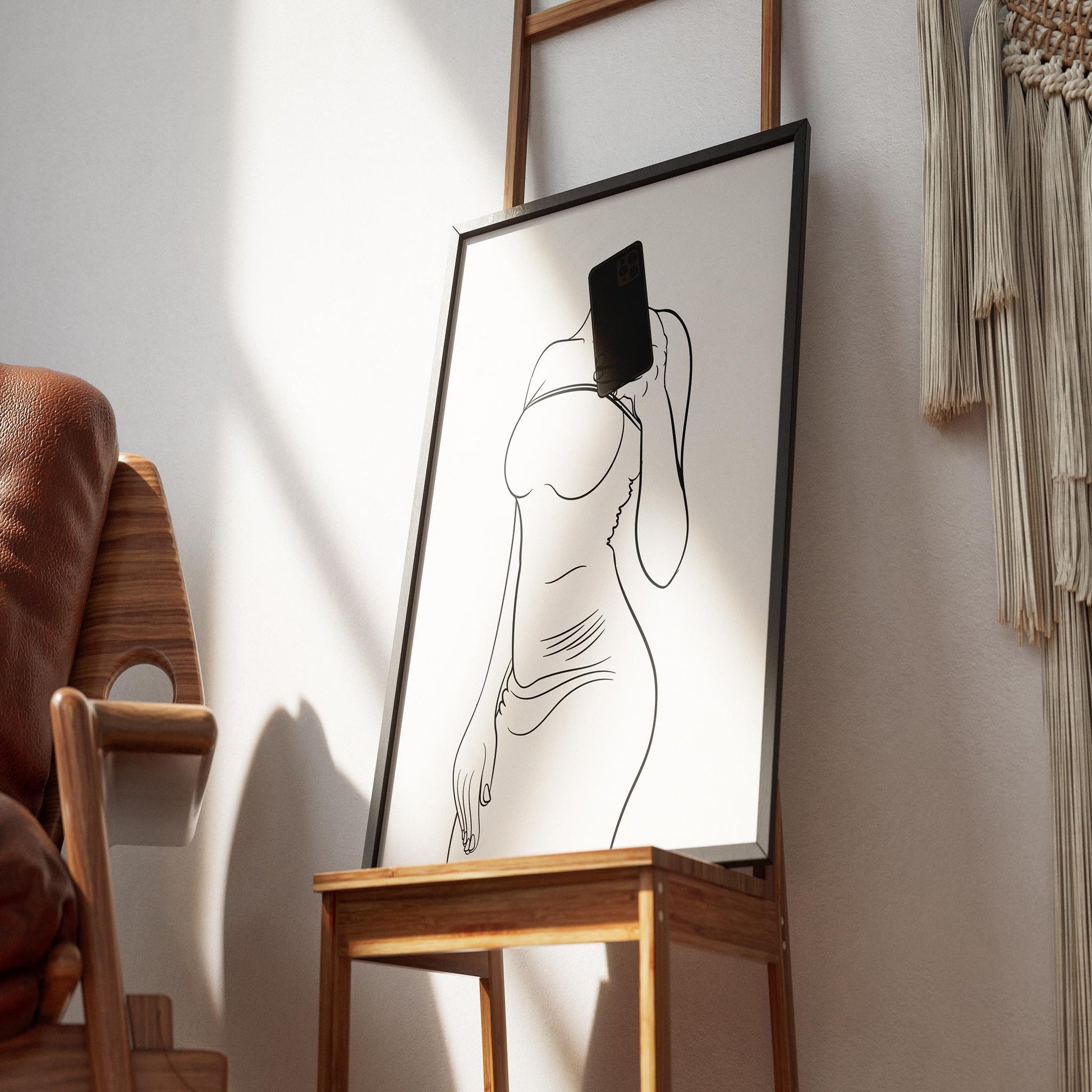 Minimalist line art of a woman in a modern dress holding a smartphone, framed and displayed as elegant wall decor.