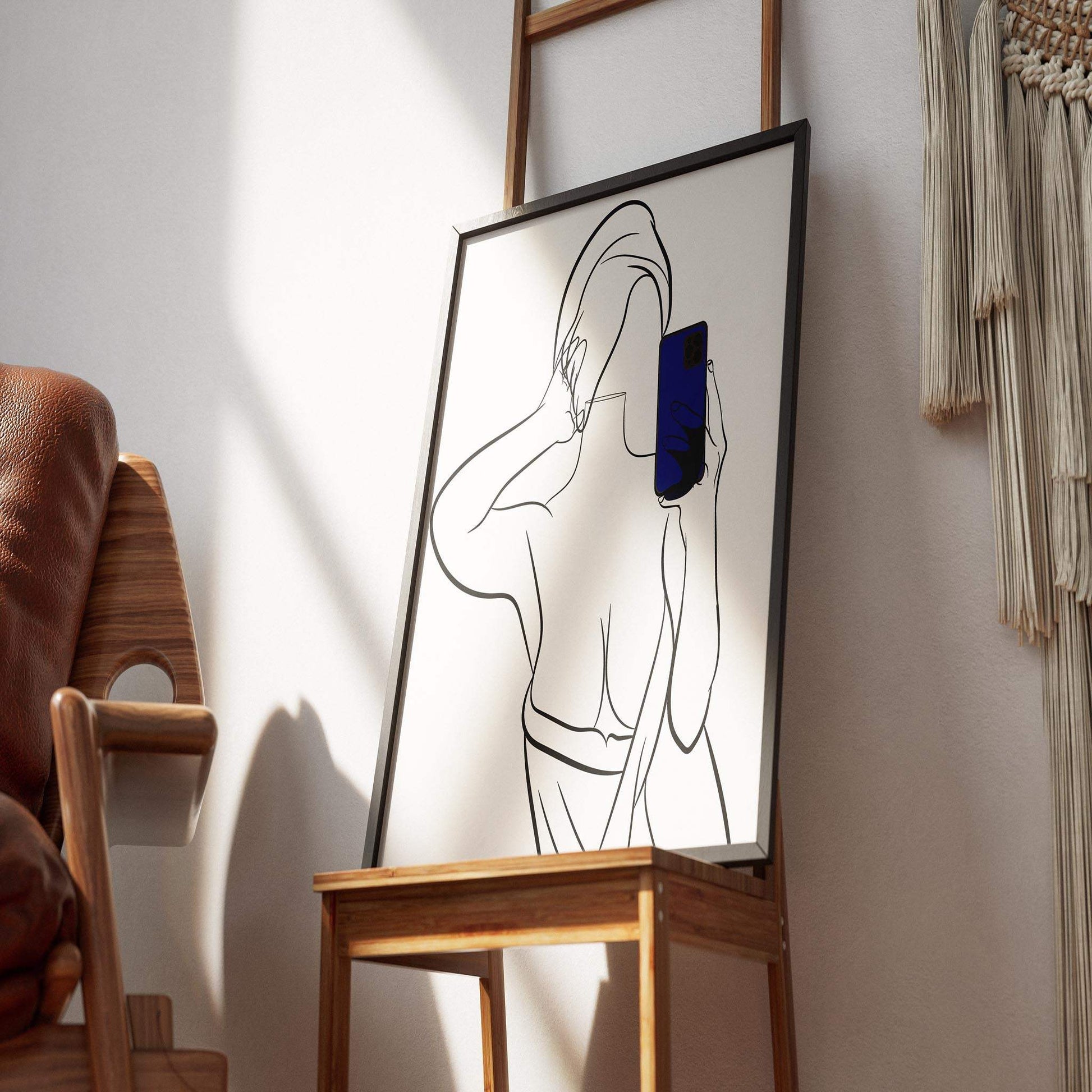 Modern illustration of a stylish figure in bold line art, framed and displayed on a chair.