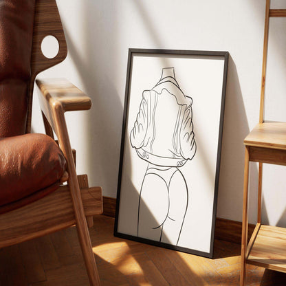 Framed line art of Model 33, showcasing bold curves and a stylish silhouette, displayed in a cozy living space.