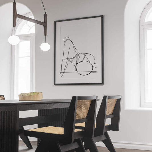 Framed digital artwork of a bikini model line art displayed in a modern dining room.